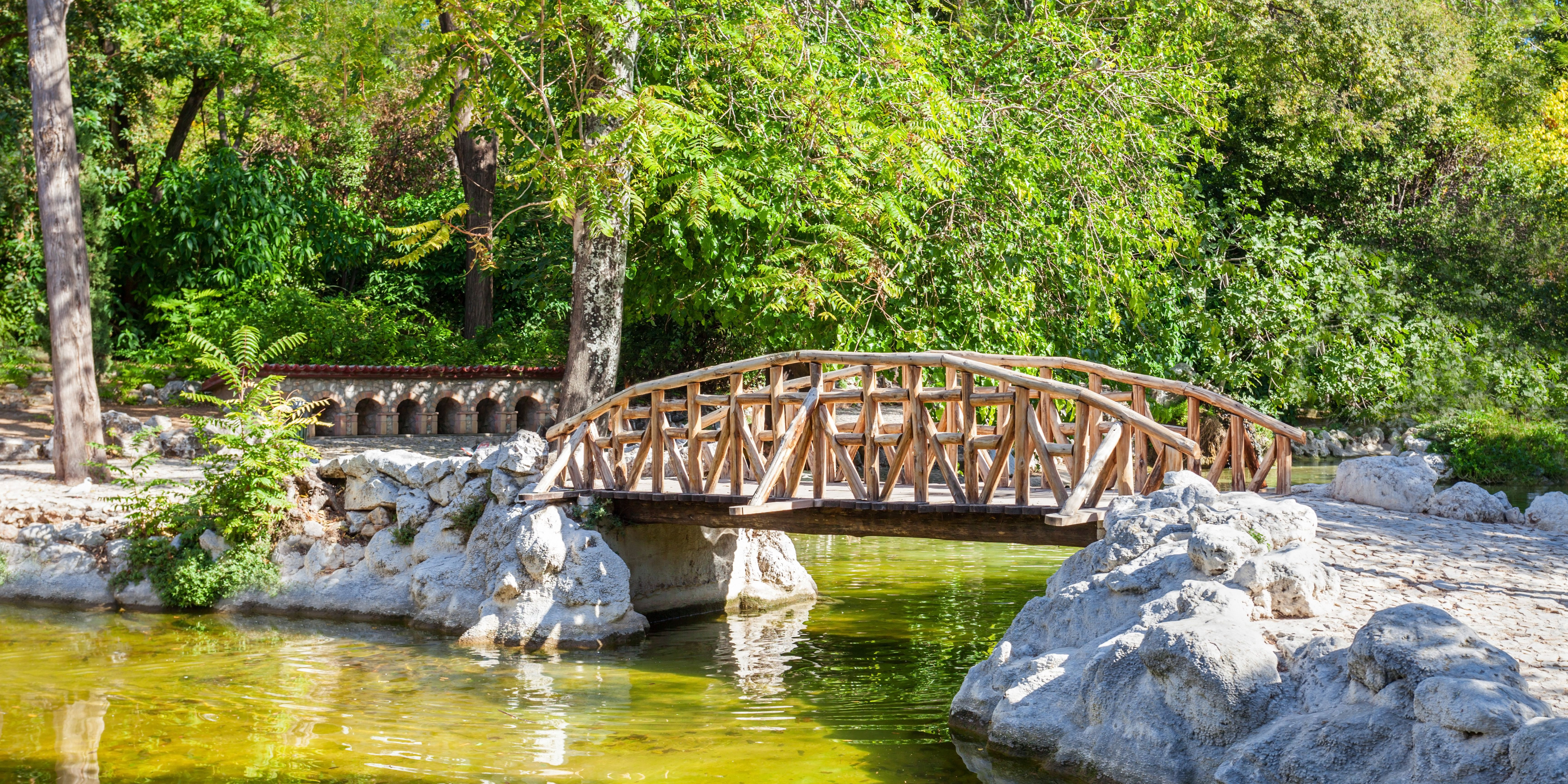 A wooden bridge over a pond in the National Gardens of Athens.